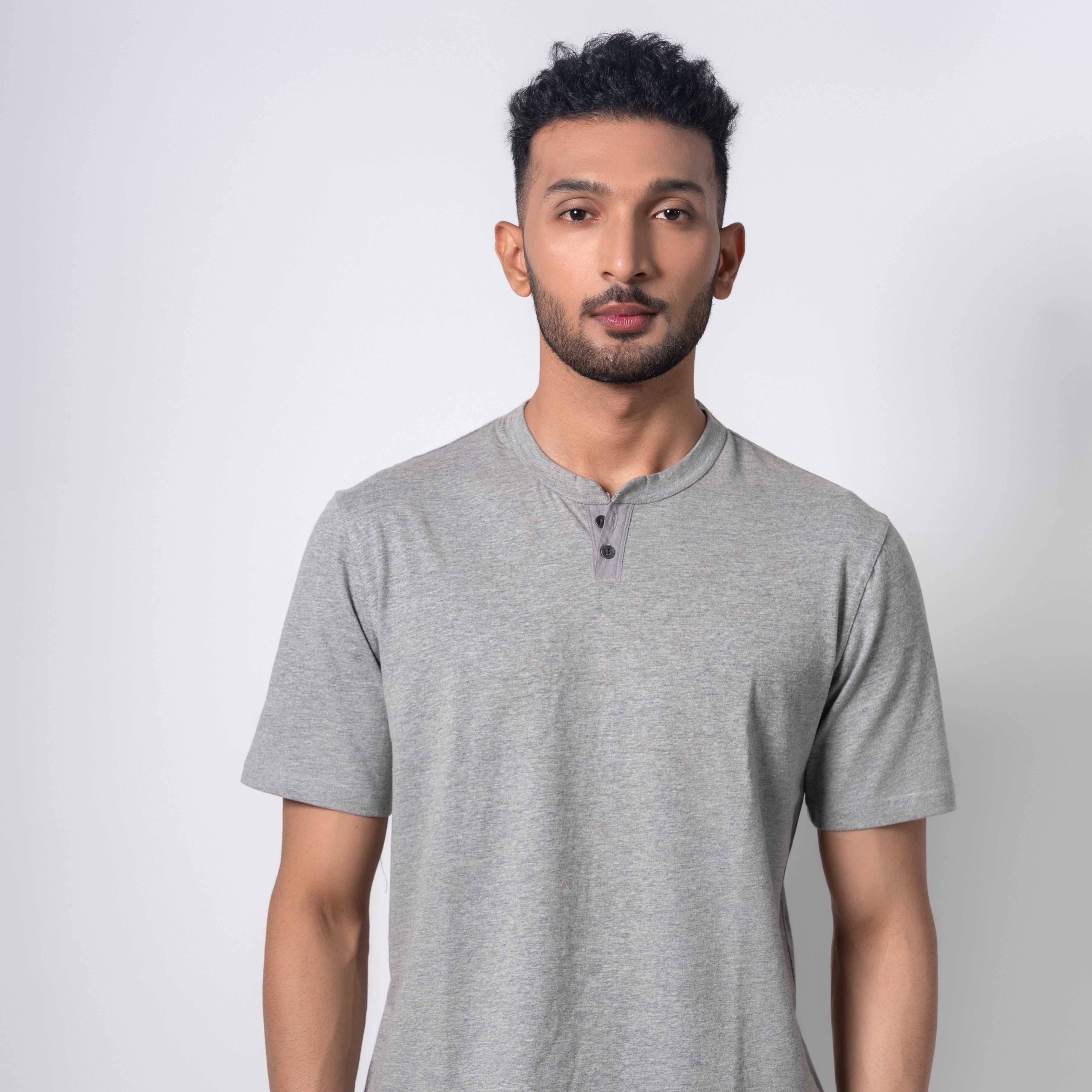 Man wearing a gray henley shirt against a white background