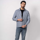 Man wearing a light gray jacket and pants on a white background